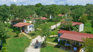 Luftaufnahme von Istrian Home Chalets mit roten Dächern, umgeben von grünen Bäumen und Rasenflächen.