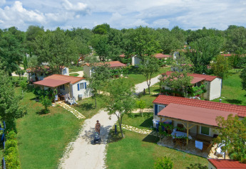 Luchtfoto van Istrian Home chalets met rode daken, omgeven door groene bomen en grasrijke paden.