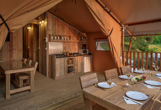 Indretning af Glamping-telt ved Valamar Camping Lanterna i Kroatien med spisebord og køkkenhjørne.