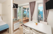 Innenaufnahme des Lanterna Home Seaside Chalets mit Esstisch, Terrasse und Meerblick in Kroatien.
