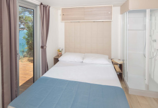Schlafzimmer im Lanterna Home Seaside Chalet im Valamar Camping Lanterna, mit Meerblick in Kroatien.