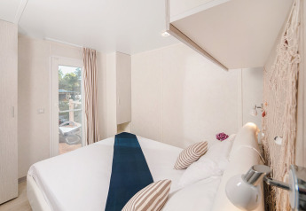 Slaapkamer in het Marine Home chalet op Valamar Camping Lanterna in Kroatië met een modern interieur.