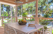 Holzterrasse mit Esstisch, Stühlen und Obstschale im Marine Home Chalet bei Valamar Camping Lanterna, Kroatien.
