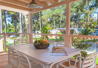 Houten terras met eettafel, stoelen en fruitschaal bij Marine Home chalet op Valamar Camping Lanterna, Kroatië.