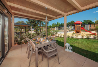 Udendørs spiseplads på en overdækket terrasse ved Mediterranean Garden Home i Valamar Camping Lanterna, Kroatien.