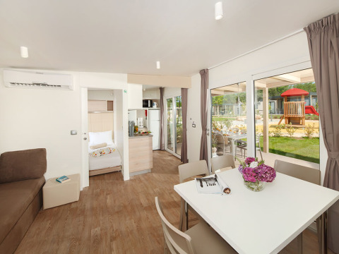Indendørs udsigt over stuen og spisestuen i en middelhavschalet på Valamar Camping Lanterna i Kroatien.