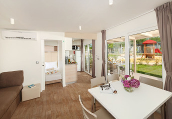 Indendørs udsigt over stuen og spisestuen i en middelhavschalet på Valamar Camping Lanterna i Kroatien.