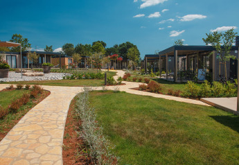 Sti og græsplæne mellem moderne chalets i Mediterranean Garden Home ved Valamar Camping Lanterna, Kroatien.