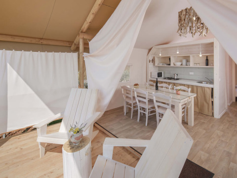 Binnenzicht op de Glamping Superior Safari Tent met keuken en eetruimte op Camping Lanterna, Kroatië.