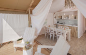 Interior view of Glamping Superior Safari Tent with kitchen and dining area at Camping Lanterna, Croatia.