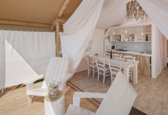 Vista interior de la tienda Glamping Superior Safari con cocina y comedor en Camping Lanterna, Croacia.