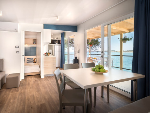Intérieur lumineux du chalet Marbello Home au Valamar Camping Lanterna en Croatie, terrasse vue sur mer.