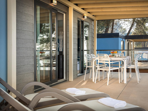 Terrasse extérieure du chalet Marbello Home à Valamar Camping Lanterna, Croatie, avec table et transats.