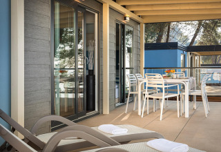 Terrasse extérieure du chalet Marbello Home à Valamar Camping Lanterna, Croatie, avec table et transats.