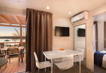 Moderne glamping-indkvartering med spiseplads, fladskærms-tv, aircondition og terrasse med udsigt.