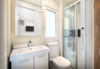 Moderne badkamer met douche, toilet en wastafel in een glampingverblijf genaamd Happy Dog Home.