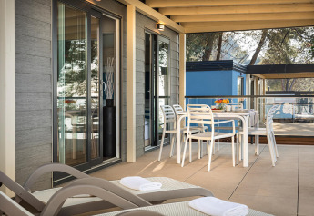 Buitenterras bij Marbello Home van Valamar Camping Lanterna, Kroatië, met tafel en ligbedden.