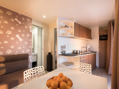 Moderne chaletkeuken en eethoek met hondenthema bij Happy Dog Home, Valamar Camping Lanterna, Kroatië.