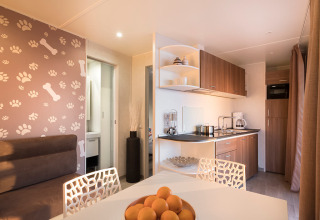 Moderne chaletkeuken en eethoek met hondenthema bij Happy Dog Home, Valamar Camping Lanterna, Kroatië.