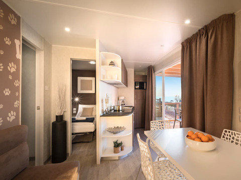 Modern chalet Happy Dog Home bij Valamar Camping Lanterna in Kroatië met eetgedeelte en uitzicht op zee.