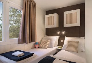 Moderne chaletkamer in Happy Dog Home, Valamar Camping Lanterna, Kroatië, met twee eenpersoonsbedden en raam.