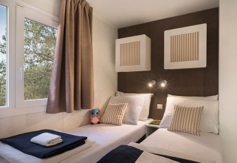 Moderne chaletkamer bij Happy Dog Home, Valamar Camping Lanterna, Kroatië, met twee bedden en een raam.