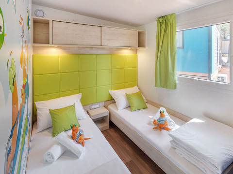 Kids' room at Maro Home, Valamar Camping Lanterna, Croatia, with twin beds, green decor, and playful style.