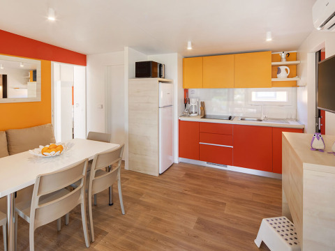 Cuisine et salle à manger modernes du chalet Maro Home au Valamar Camping Lanterna en Croatie, tons vifs.