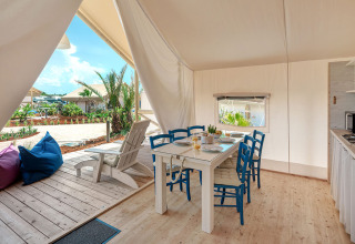 Binnenzicht van de Maro Premium Glamping Tent met eettafel en terras bij Valamar Camping Lanterna, Kroatië.