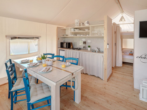 Interieur van de Maro Premium Glamping Tent bij Valamar Camping Lanterna in Kroatië met keuken en eetruimte.