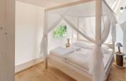 Helles Schlafzimmer mit Himmelbett im Maro Premium Glamping Zelt bei Valamar Camping Lanterna, Kroatien.