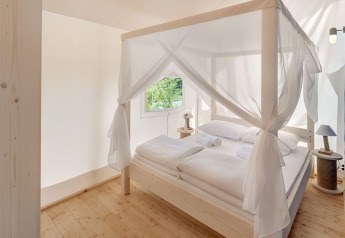 Lichte en elegante slaapkamer met hemelbed in Maro Premium Glamping Tent op Valamar Camping Lanterna, Kroatië.