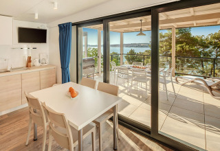 Intérieur de la Marbello Suite au Valamar Camping Lanterna, coin repas, terrasse et vue sur la mer.