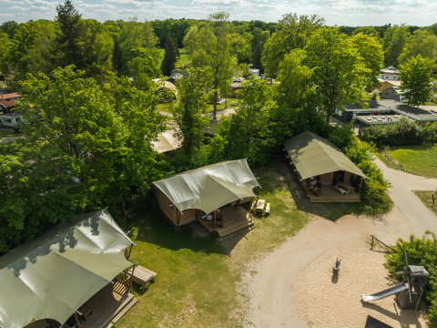 Aerial view of safari tents with bathrooms at Holiday Park Mölke, surrounded by greenery in the Netherlands.