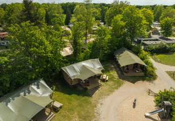 Vista aerea delle tende safari con bagno al Holiday Park Mölke, circondate dal verde nei Paesi Bassi.