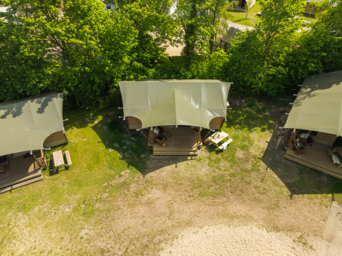 Luchtfoto van een safaritent met badkamer in Holiday Park Mölke, Nederland, omgeven door natuur en bomen.
