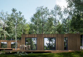 Modernes Holzhaus in der Eco Lodge im Hameau de l'Ourthe, Belgien, von Bäumen und Natur umgeben.