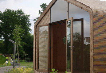 Vista esterna della Wrap house con sauna e vasca da bagno al Resort de Parel, nei Paesi Bassi, nel verde.
