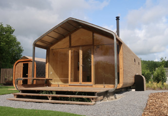Lodge Wrap house con sauna e vasca da bagno al Resort de Parel nei Paesi Bassi, immerso nel verde.