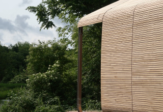 Vista exterior de la cabaña Wrap house con sauna y bañera en el Resort de Parel, Países Bajos, rodeada de naturaleza.