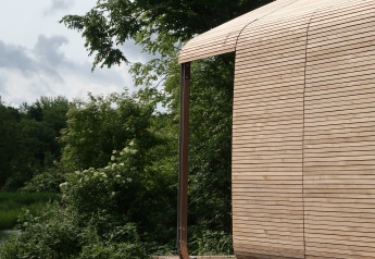 Vista esterna del lodge Wrap house con sauna e vasca da bagno presso Resort de Parel nei Paesi Bassi, immerso nella natura.