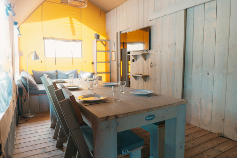 Binnenaanzicht van Ranger Lodge safaritent op Vakantiepark Sallandshoeve in Nederland, met eettafel.
