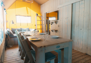 Binnenaanzicht van Ranger Lodge safaritent op Vakantiepark Sallandshoeve in Nederland, met eettafel.