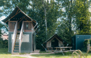 Cabaña safari XS con baño privado en Holiday Park Sallandshoeve, rodeada de árboles y naturaleza.