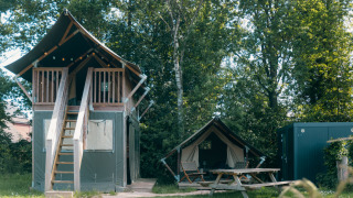 Safari cottage XS avec sanitaires privés au Holiday Park Sallandshoeve, entouré d’arbres verdoyants.