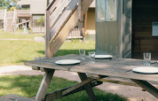 Mesa de picnic al aire libre con platos y vasos en Safaricottage XS, Holiday Park Sallandshoeve, Países Bajos.