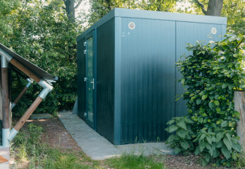 Vue extérieure du Safaricottage XS et unité sanitaire privée au Holiday Park Sallandshoeve, Pays-Bas.