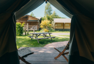 Blick aus einem Safarizelt mit Terrasse und Sitzbereich im Holiday Park Sallandshoeve, Niederlande.