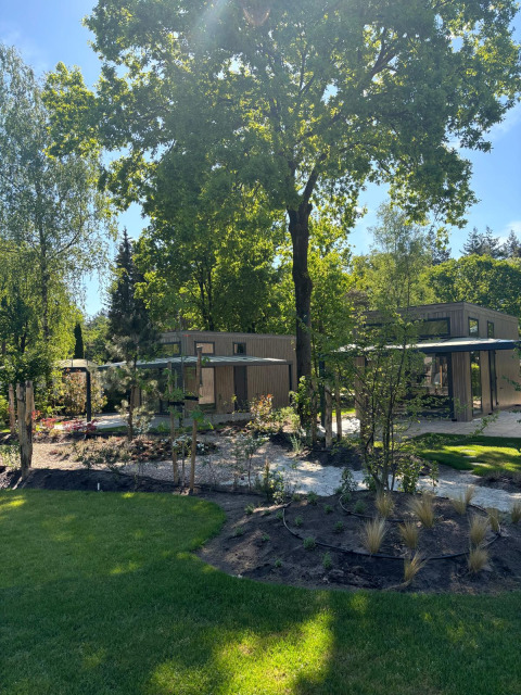 Sonniger Tag bei Reeëndal Lodge im Veluwepark de Bosgraaf in den Niederlanden, umgeben von Natur.