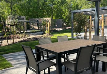 Outdoor dining area under a covered patio at Reeëndal Lodge, Veluwepark de Bosgraaf, Netherlands.